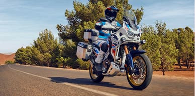 Motocicleta de aventura estacionada en una carretera arbolada
